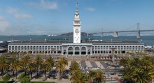 Das San Francisco Ferry Building bei Tag mit der Bay Bridge im Hintergrund